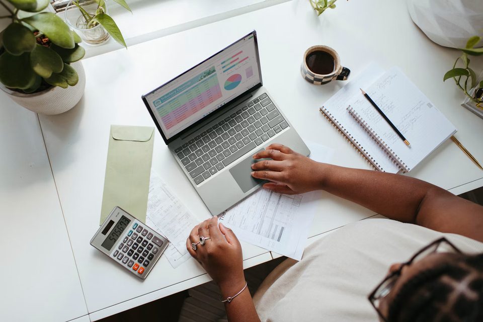 Accounting workspace with a laptop, calculator, and financial documents